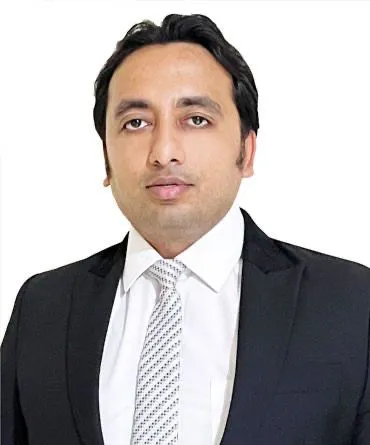 Portrait of Digant Sharma, founder of NavyExporter, wearing a dark suit, white shirt and patterned tie